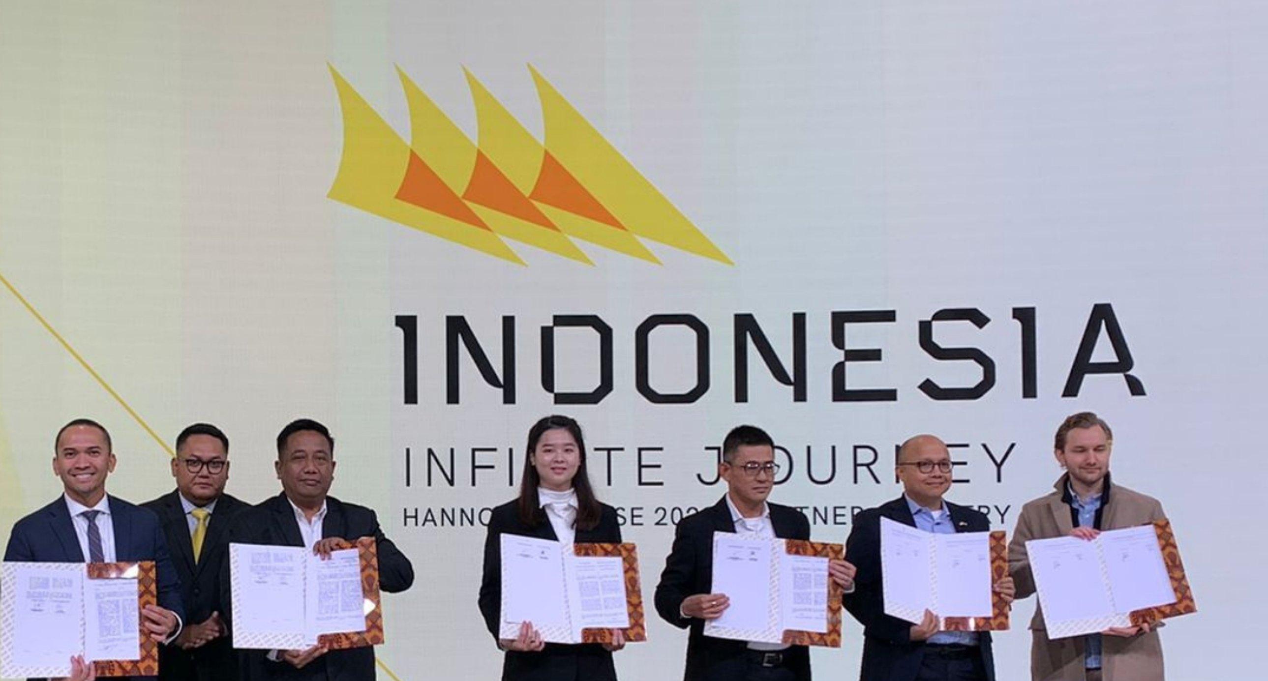 Signers hold up their agreements on stage at Hannover Messe 2023