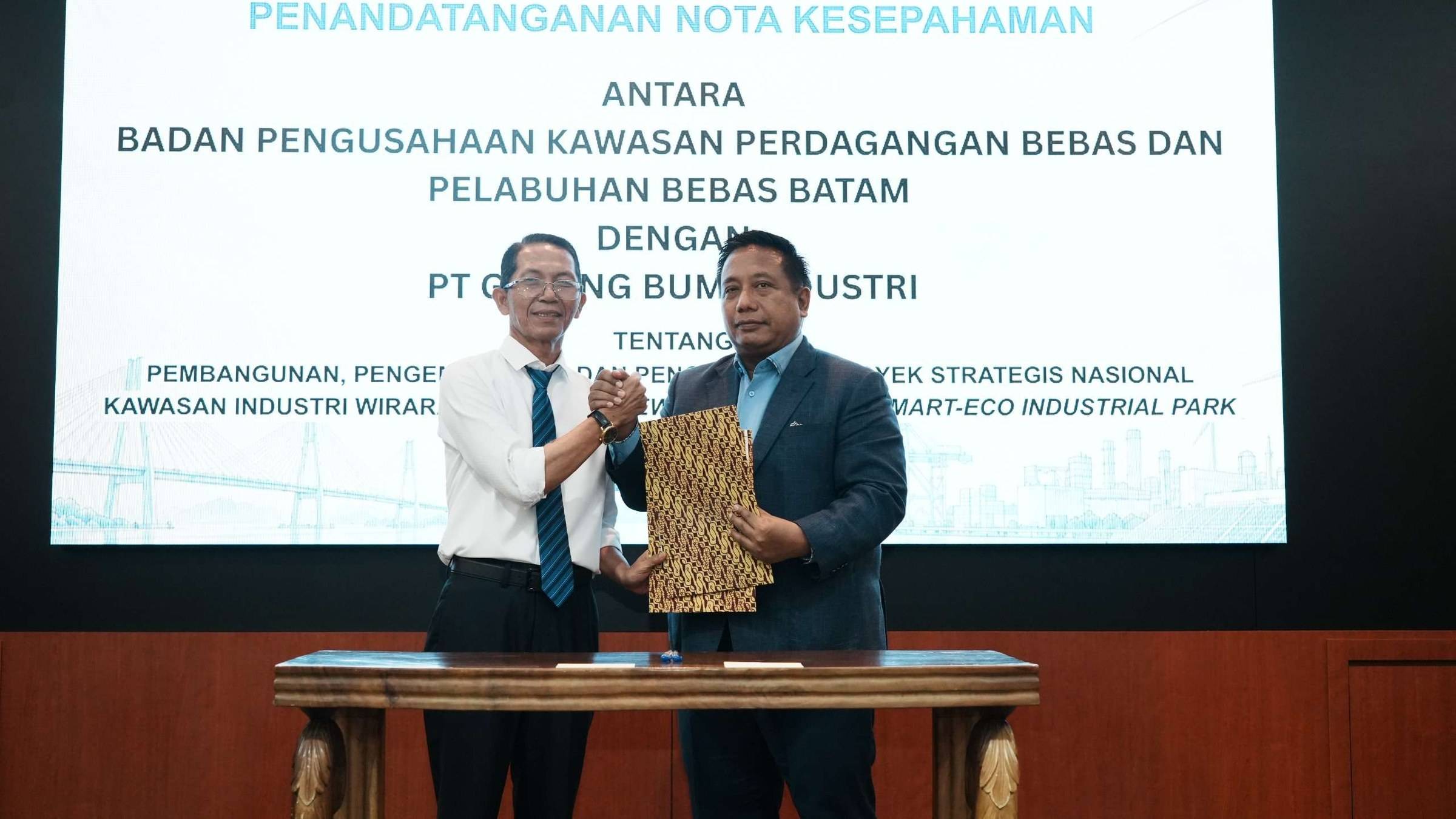 Amsakar Achmad, Head of BP Batam, and Akhmad Ma’ruf Maulana, President Director of PT Galang Bumi Industri, shake hands after the signing