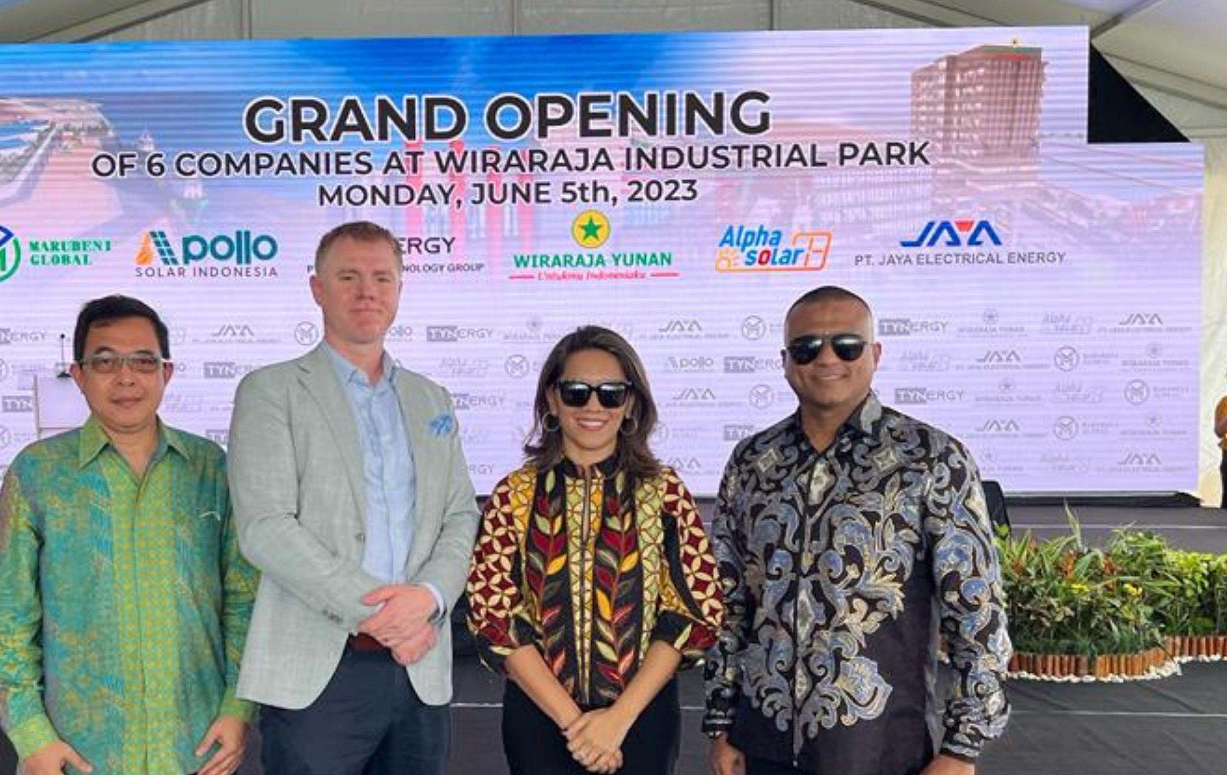 Four guests stand in front of the Grand Opening banner at Wiraraja Industrial Park